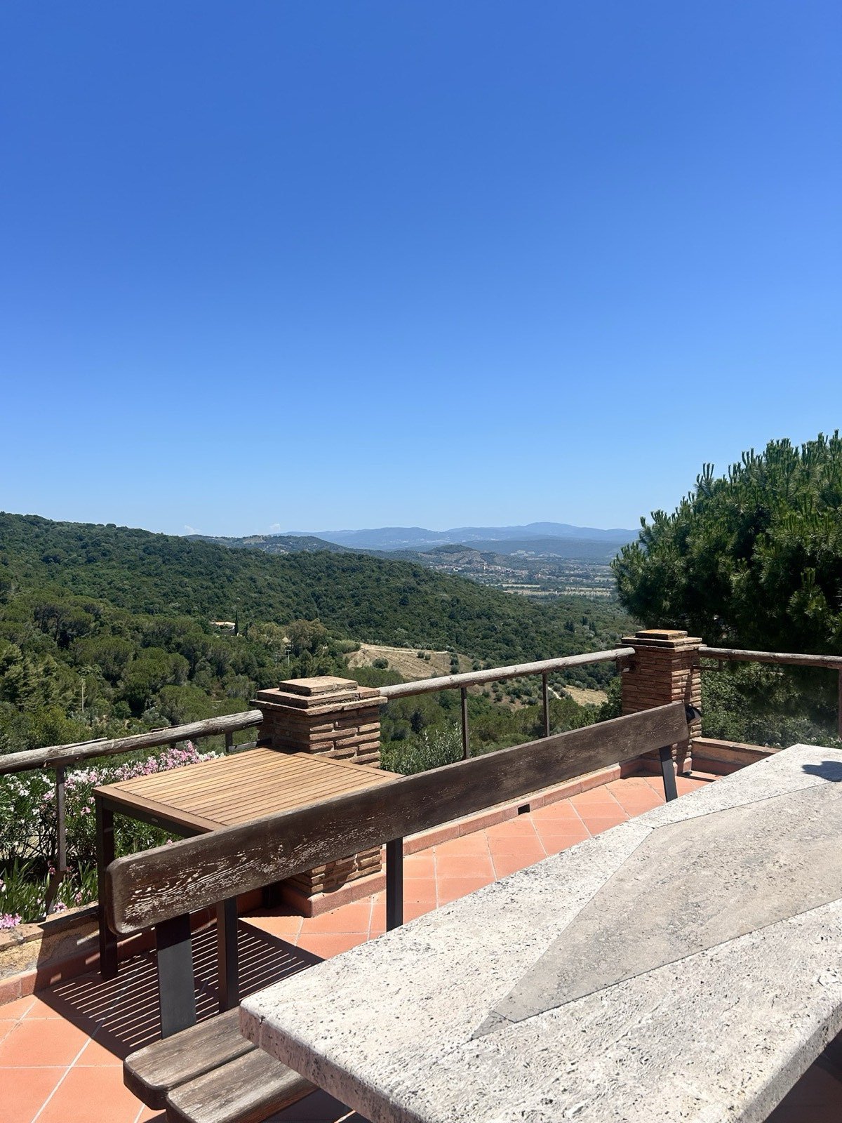 La terrazza con il tavolo in legno affacciata sulle colline